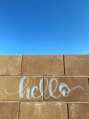 handlettered hello on a block wall